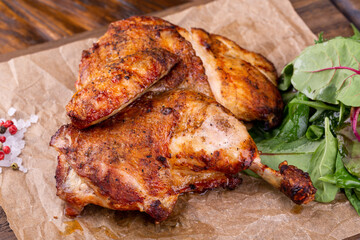 Chicken legs on grilled bones with greens and spices