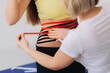 © dsheremeta - Kinesio tape on girl belly. Young caucasian girl with kinesiology elastic therapeutic tape on her belly. Woman Applying Special Physio Tape On Woman's abdomen