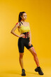 © dsheremeta - Young caucasian girl with kinesiology tape on her belly and leg, on yellow background. Sport and rehabilitation, kinesiotherapy treatment.
