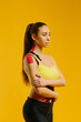© dsheremeta - Young caucasian girl with kinesiology tape on her belly and leg, on yellow background. Sport and rehabilitation, kinesiotherapy treatment.