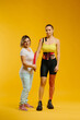 © dsheremeta - Female therapist applying kinesio tape on a woman's arm on the yellow background. Woman prepares patient to glue adhesive tape on hand