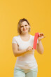 © dsheremeta - A therapist rolling kinesiology tape to demonstrate it on the yellow background. Alternative kinesio tape therapy, healthcare concept
