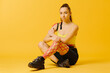 © dsheremeta - Young caucasian girl with kinesiology tape on her belly and leg, on yellow background. Sport and rehabilitation, kinesiotherapy treatment.