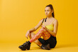 © dsheremeta - Young caucasian girl with kinesiology tape on her belly and leg, on yellow background. Sport and rehabilitation, kinesiotherapy treatment.