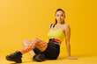 © dsheremeta - Young caucasian girl with kinesiology tape on her belly and leg, on yellow background. Sport and rehabilitation, kinesiotherapy treatment.