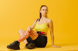 © dsheremeta - Young caucasian girl with kinesiology tape on her belly and leg, on yellow background. Sport and rehabilitation, kinesiotherapy treatment.