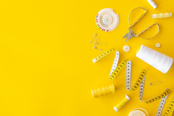 Wall Mural - Cutting and sewing tool kit flat lay. Yellow and white tools set for sewing on a yellow background. Top view with copy space