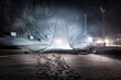 Ski jump at night illuminated by lights covered with snow. Winter sport season. Wide shot, looking up
