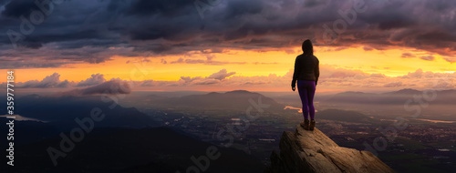 Fotomural Fantasy Adventure Composite with a Girl on top of a Rock Cliff with Beautiful Nature in Background during Sunset or Sunrise