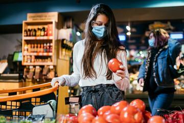 The girl with surgical mask is going to buy tomatos.