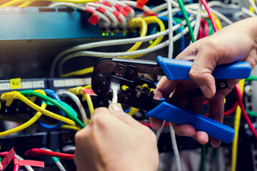 Selective focus to RJ45 Connector with crimping RJ45 tool on blurry background of UTP cable and computer network in computer room.
Stepping to crimping RJ45 connector. Connection procedure UTP cable.