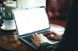 © panitan - computer mockup image blank screen.hand woman work using laptop with white background for advertising,contact business search information on desk at coffee shop.marketing and creative design