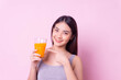 Healthy woman diet drinking orange juice for health, sport portrait  asian girl isolated pink background,healthy drink and clean food concept,copy space