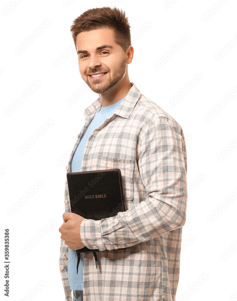 Young man with Bible on white background