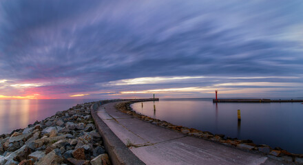 Wall Mural - breakwater at the entrance to port during sunset