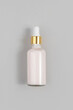Pink anti-aging collagen, facial serum in transparent glass bottle with gold pipette on grey background. Natural Organic Spa Cosmetic Beauty Concept. Top view Flat lay