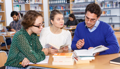 Wall Mural - Teacher working with female students in library