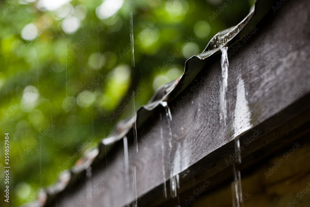 Ściekająca woda z dachu podczas deszczu. - obrazy, fototapety, plakaty 