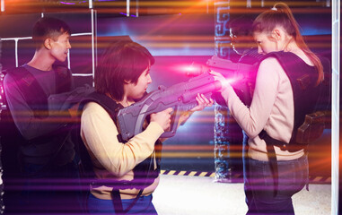 Wall Mural - girls standing face to face with laser guns on lasertag gaming a