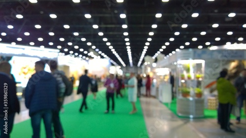 Abstract blur people in trade show background. New modern exhibition, convention and conference expo centre. Venue for holding business. Financial and economic growth and crisis concept. Collaboration