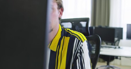 Wall Mural - Creative entrepreneur sitting at his desk works on desktop computer in the stylish office