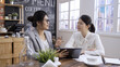 © PRPicturesProduction - two women consultants doing business conference in meeting cafe store. young office lady in suit asking colleague advice in coffee shop. asian korean female colleagues discussing on digital tablet.