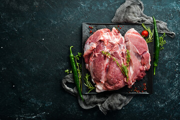 Wall Mural - Piece of fresh raw pork from the neck, with ingredients and spices on a kitchen background. Meat. Top view. Rustic style.