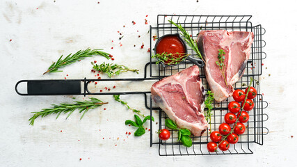 Raw aged T-bone steak with rosemary on a white wooden background. Top view. Rustic style.