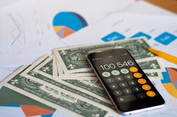 Close up of hands counting money with calculator