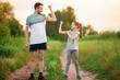 © Svetlana - Full length portrait of handsome father and his cute little daughter showing their muscles, looking at camera and smiling at sunset