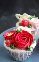 Closeup Cupcakes Decorated With Red Flower Shaped Frosting On Pale Blue Plate