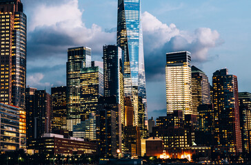 Wall Mural - Scenery view of Lower Manhattan skyline at evening with city lights in windows. Beautiful cityscape view of New York downtown. Contemporary metropolis city in need of a huge amount of electricity