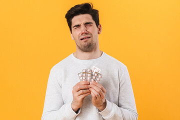 Canvas Print - Photo of unhappy man with allergy posing with medicine and crying