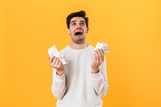 Photo of bristle unhappy man with allergy posing with pills and napkin