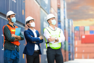 Wall Mural - Group of professional team worker wearing protection face mask during coronavirus and flu outbreak and wearing safety hardhat helmet at container yard or cargo warehouse