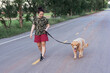 © Achira22 - Asian woman with her golden retriever dog walking on the public road..