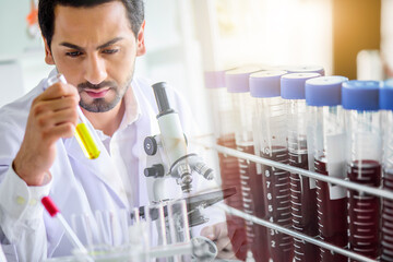 lab technician assistant analyzing a blood sample service in test tube at laboratory with microscope. Medical, pharmaceutical and scientific research and development concept.