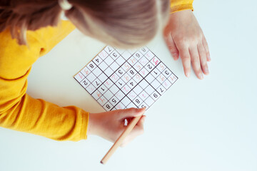 Teen girl solving sudoku at school or at home. View from above