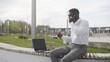 © stanis88 - Busy african businessman having lunch and working outdoors