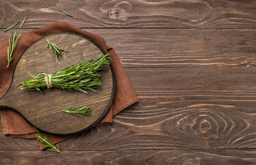 Wall Mural - Fresh rosemary sprigs on rustic kitchen table