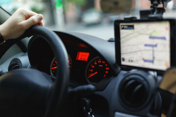 View of a speedometer, steering wheel and navigator on a dashboard