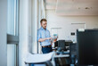 © Westend61 - Businessman standing at the window in office using tablet