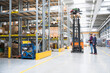 © Westend61 - Two men and worker on forklift in high rack warehouse