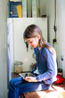 © Westend61 - Girl sitting on worktop in the kitchen looking at digital tablet