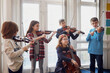© Westend61 - Group of children playing violin during a lesson