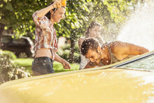 Friends Washing Yellow Vintage Car In Summer Having Fun