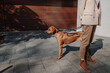 © Westend61 - Crop view of fashionable woman standing on pavement with her dog