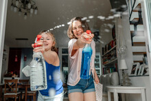 Two Sisters Splashing With Window Cleaner
