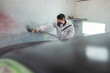© Westend61 - Body painter painting car in paint booth
