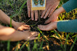 © Westend61 - Cropped hands of family planting together in garden
